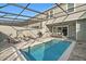 Inviting screened-in pool area, complete with lounge chairs, grill, and patio furniture at 1283 Blue Paradise Way, Clermont, FL 34714
