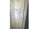 Well-lit hallway leading to a kitchen area with tile flooring, creating a seamless transition between spaces at 13046 Prairie Meadows Dr, Orlando, FL 32837