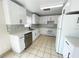 Modern kitchen with white cabinets, stainless steel appliances, and tile flooring, perfect for cooking at 13046 Prairie Meadows Dr, Orlando, FL 32837