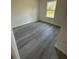 A cozy bedroom featuring one large window providing natural light and wood-look vinyl floors at 13265 Sw 85Th Cir, Ocala, FL 34473