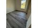 Bright bedroom with gray wood-look floors and a window providing natural light at 13265 Sw 85Th Cir, Ocala, FL 34473
