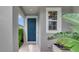Inviting front door entrance with a blue door, window, and a welcome mat, surrounded by plants at 1396 Riley Cir, Deland, FL 32724