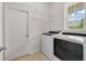 Well-lit laundry room includes a washer and dryer, tiled floor, and shelving space for storage at 1396 Riley Cir, Deland, FL 32724
