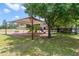 Community playground featuring a covered play structure, slides, and benches in a green, tree-lined setting at 1396 Riley Cir, Deland, FL 32724