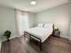 Clean bedroom with a full bed frame, bright natural light, and wood flooring at 14 Fir Trail Way, Ocala, FL 34472