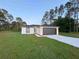 Well-maintained single-story home with a modern design, gray garage door, and green lawn at 14 Fir Trail Way, Ocala, FL 34472