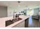 Modern kitchen featuring stainless steel sink, gray cabinets, and an open concept design at 14 Fir Trail Way, Ocala, FL 34472