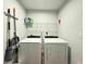 Functional laundry room equipped with a washer and dryer, shelving, and cleaning supplies at 14 Fir Trail Way, Ocala, FL 34472