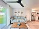 Cozy living room featuring modern decor, a gray sofa, and a large sliding glass door at 14 Fir Trail Way, Ocala, FL 34472