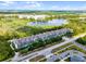 Stunning aerial view of the condo building complex featuring a serene lake and lush green surroundings at 14200 Avalon Rd # 409, Winter Garden, FL 34787