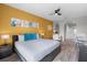 Comfortable bedroom featuring vibrant wall decor, a spacious layout, and an adjacent bathroom and workspace at 14200 Avalon Rd # 409, Winter Garden, FL 34787