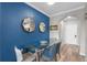 Chic dining room with blue accent wall, a glass top table, stylish chairs, and decorative mirrors at 14200 Avalon Rd # 409, Winter Garden, FL 34787