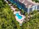 Aerial view of the community pool area surrounded by mature trees and lounge chairs at 14200 Avalon Rd # 409, Winter Garden, FL 34787