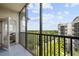 Screened-in balcony with a view of the building's exterior and green space beyond at 14501 Grove Resort Ave # 3636, Winter Garden, FL 34787