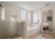 Modern bathroom featuring a glass-enclosed shower, soaking tub, and elegant white tile at 14501 Grove Resort Ave # 3636, Winter Garden, FL 34787