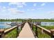 Scenic view of a dock with a covered pavilion extending into a calm lake, surrounded by lush greenery at 14501 Grove Resort Ave # 3636, Winter Garden, FL 34787
