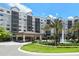 Elegant multi-story resort building with a grand entrance, porte-cochère, fountain, and beautifully landscaped grounds at 14501 Grove Resort Ave # 3636, Winter Garden, FL 34787