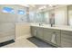 Bright bathroom featuring double sinks, gray cabinets, white countertops, and a large glass enclosed shower at 16410 Good Hearth Blvd, Clermont, FL 34711