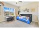 Cozy bedroom featuring a comfy daybed, a large window with natural light, and decorative wall art at 16410 Good Hearth Blvd, Clermont, FL 34711