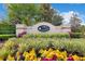 Community entrance sign featuring lush landscaping and colorful flowers under a bright sky at 16410 Good Hearth Blvd, Clermont, FL 34711
