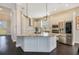 Modern kitchen featuring white cabinetry, stainless steel appliances, and a large island with granite countertops at 16410 Good Hearth Blvd, Clermont, FL 34711