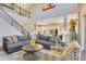 Open-concept living room with a grand staircase, stylish furnishings, and seamless flow into the kitchen area at 16410 Good Hearth Blvd, Clermont, FL 34711