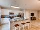 Modern kitchen featuring white cabinets, stainless steel appliances, a granite island with seating, and tile flooring at 17081 Water Spring Blvd, Winter Garden, FL 34787