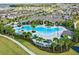 Stunning aerial view of a resort-style pool surrounded by palm trees and comfortable lounge chairs at 17081 Water Spring Blvd, Winter Garden, FL 34787
