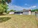 View of the backyard, featuring a screened-in lanai and a well-maintained lawn, ideal for relaxation at 186 Tulpan Dr, Kissimmee, FL 34743