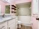 This bathroom features a combination tub and shower, a new vanity and wood shelves at 186 Tulpan Dr, Kissimmee, FL 34743