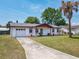 Inviting single-story home with a well-manicured lawn, an attached garage, and a welcoming front porch at 186 Tulpan Dr, Kissimmee, FL 34743