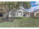 Spacious backyard with lush green grass and mature trees. The home has a large arched window at 19540 Glen Elm Way, Orlando, FL 32833