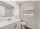 Well-lit bathroom with sleek white vanity, toilet, and a window for natural light at 19540 Glen Elm Way, Orlando, FL 32833