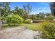 Spacious backyard featuring a mix of grass and mulch, framed by trees and foliage at 2123 Weber St, Orlando, FL 32803