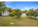 Overgrown backyard featuring mature trees, greenery, and a storage shed at 2123 Weber St, Orlando, FL 32803