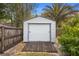 Backyard shed featuring a garage door, adjacent greenery, and wood fencing at 2123 Weber St, Orlando, FL 32803