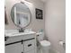 Stylish half bathroom features a round mirror, modern fixtures, and clean, contemporary design with farmhouse vanity at 2447 Hassonite St, Kissimmee, FL 34744