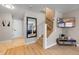 Hallway with hardwood floors and a decorative mirror leading to the living room and stairs at 2447 Hassonite St, Kissimmee, FL 34744