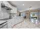 Modern kitchen featuring quartz countertops, white cabinets and tile backsplash open to the dining area at 2447 Hassonite St, Kissimmee, FL 34744