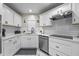 Stylish kitchen featuring quartz countertops, white cabinets and a stainless steel dishwasher and stove at 2447 Hassonite St, Kissimmee, FL 34744