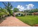 Home with brick driveway, green lawn, and mature landscaping, enhancing the property's appeal at 2491 Island Dr, Longwood, FL 32779