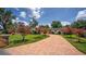 Well-manicured lawn leads to the charming front of the home with blooming crape myrtle trees at 2491 Island Dr, Longwood, FL 32779