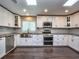 Well-lit kitchen featuring stainless steel appliances, white cabinets and skylights at 2491 Island Dr, Longwood, FL 32779