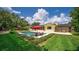 Expansive backyard showcasing a pool, lounge chairs with a red umbrella, and beautifully landscaped lawn, perfect for relaxation at 2491 Island Dr, Longwood, FL 32779