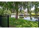 A serene waterfront view featuring a private boat dock and lush greenery, enhanced by a mature tree at 2491 Island Dr, Longwood, FL 32779