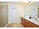 Well-lit bathroom featuring a glass-enclosed shower, vanity with sink, and ample storage space at 2660 Santosh Cv, Kissimmee, FL 34746