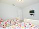 Bright bedroom with two twin beds, TV, and neutral decor, creating a cozy and inviting space at 2660 Santosh Cv, Kissimmee, FL 34746