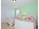 Charming bedroom with twin beds, colorful bedding, and ample natural light from the window at 2660 Santosh Cv, Kissimmee, FL 34746