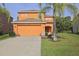 Two-story home with a two-car garage and landscaping in a well-maintained front yard at 2660 Santosh Cv, Kissimmee, FL 34746