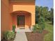 A welcoming front entrance with a dark wood door, manicured bushes and mulched flower bed at 2660 Santosh Cv, Kissimmee, FL 34746